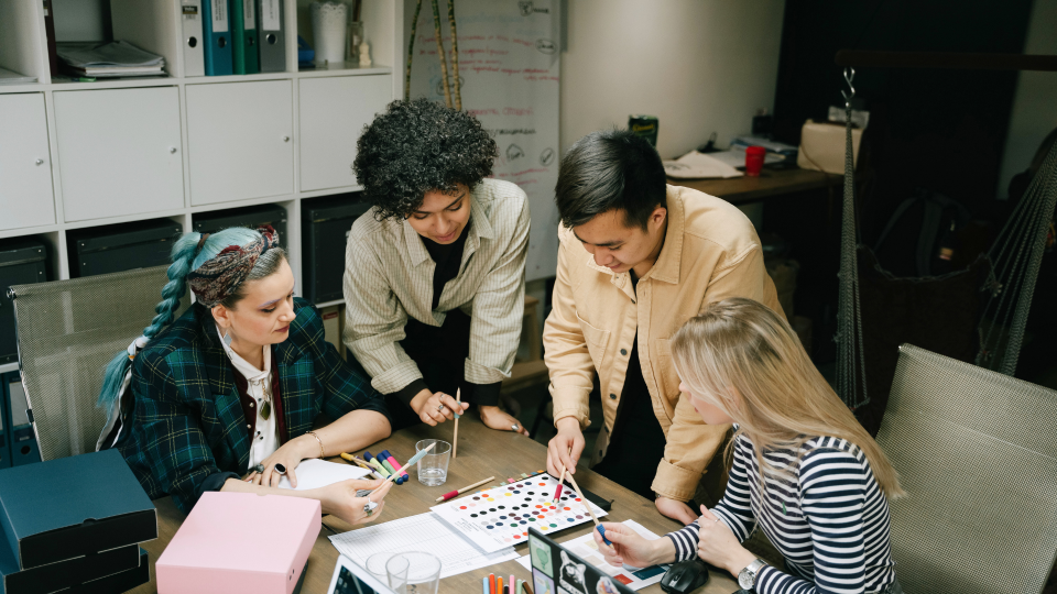 An image of 4 people looking at colour options. There are three women and one man, and they are discussing a colour chart