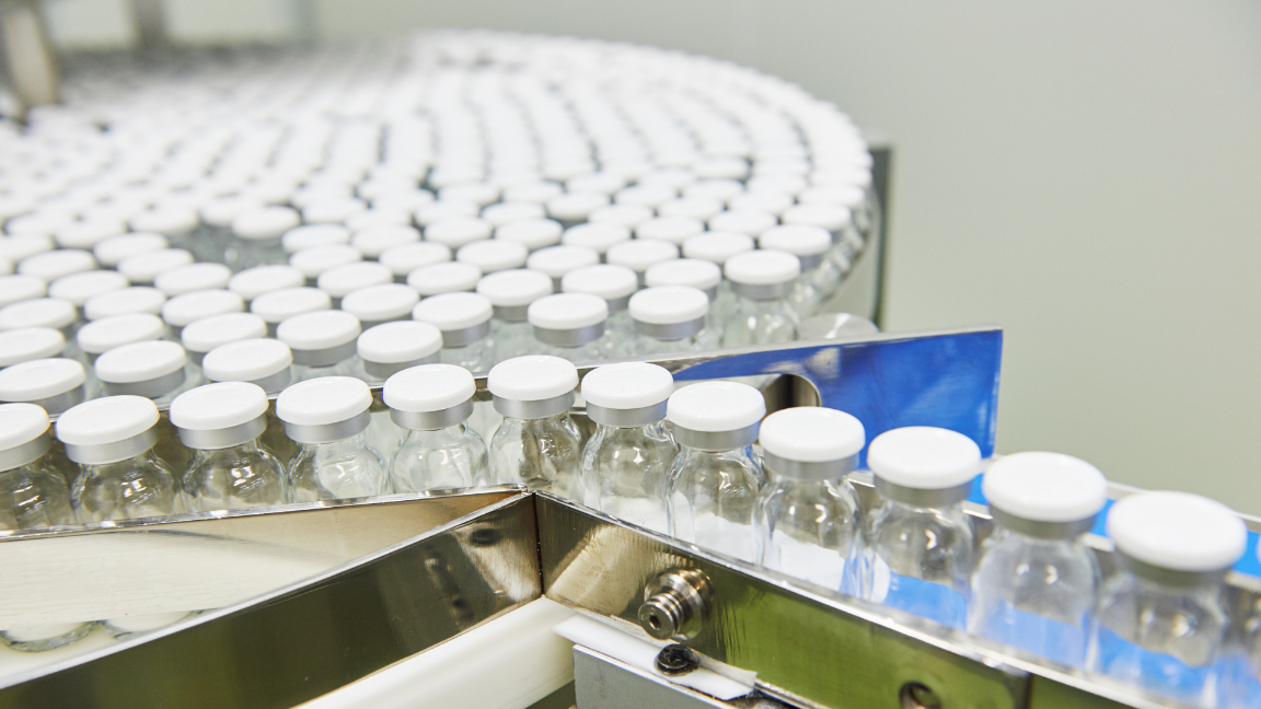 A production line of plastic bottles. The bottles are moving along a conveyor belt through the factory.