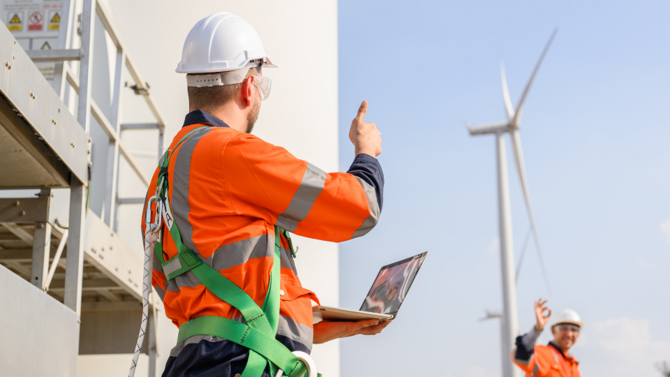 An image of two construction workers checking on a newly constructed wind-turbine