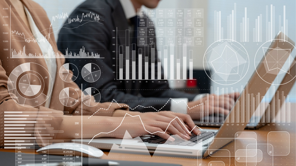 Two people working on laptops on a wooden desk. There are many charts and graphs overlayed on to the picture, suggesting business metrics