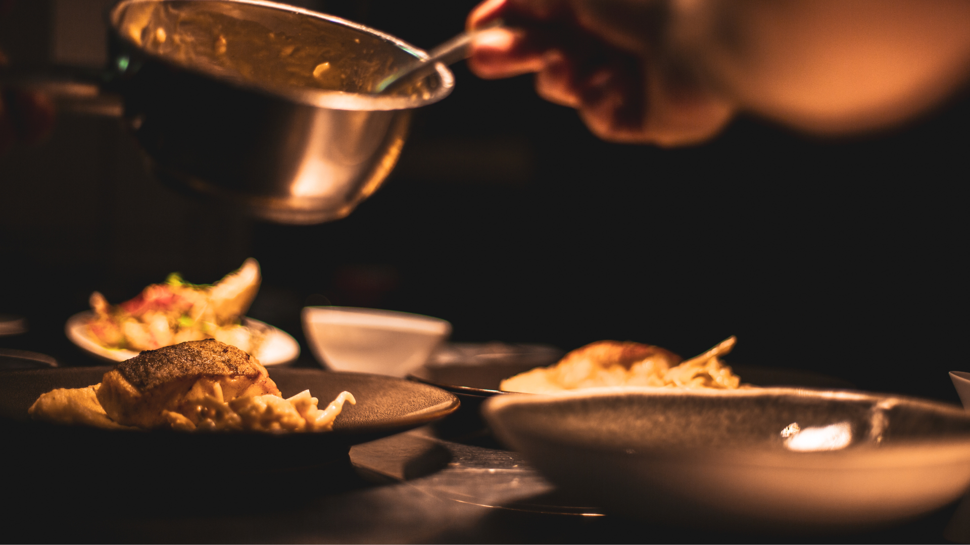 A chef preparing to add sauce to a dish