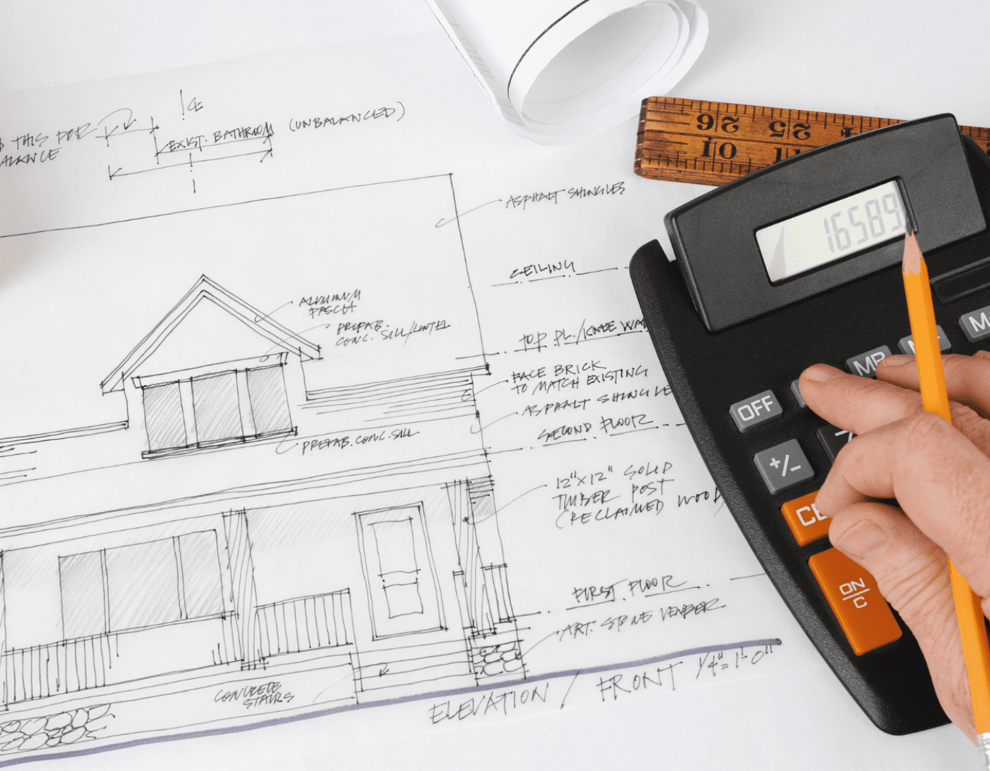 An image of a technical drawing of a construction project with a calculator and rule on top of it