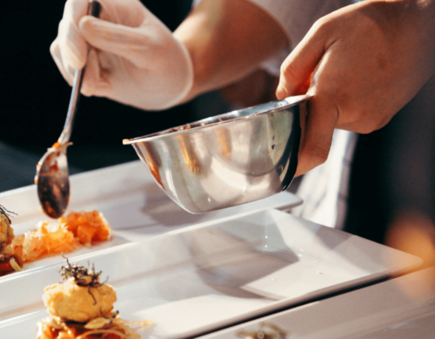 A chef adding ingredients to a dish