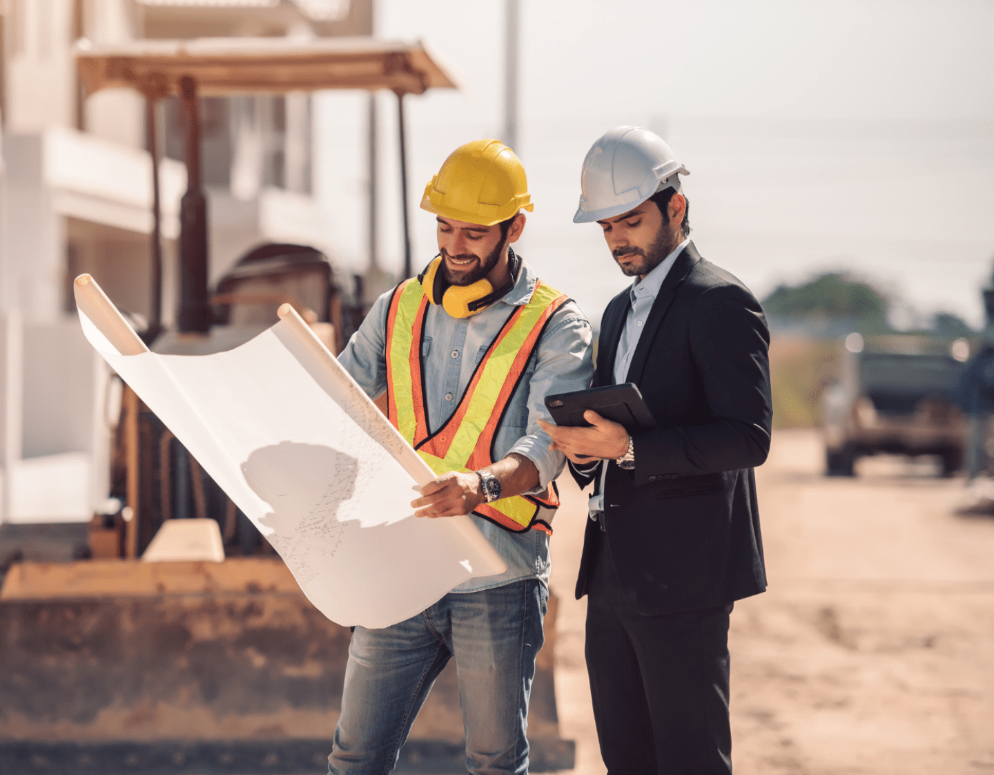 A construction Project Manager discussing technical drawings with a site worker. 