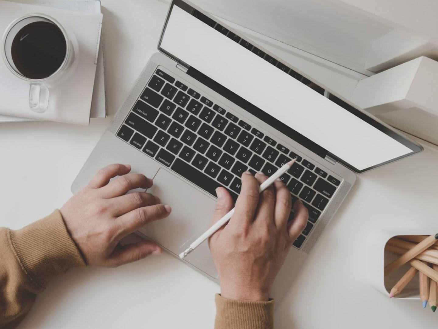 A laptop on a desk with a cup of coffee