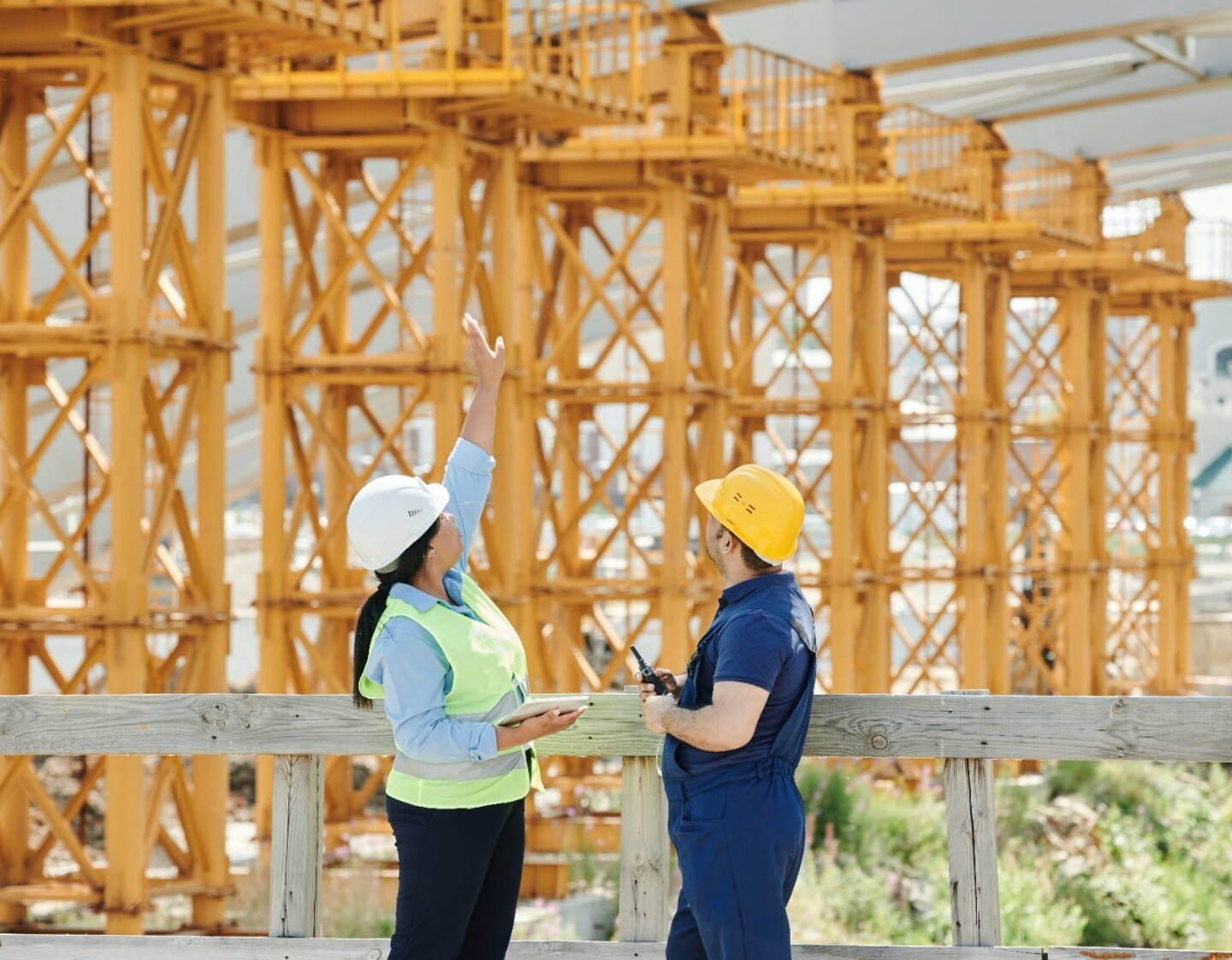 A woman and a man on a building site, looking at a structure