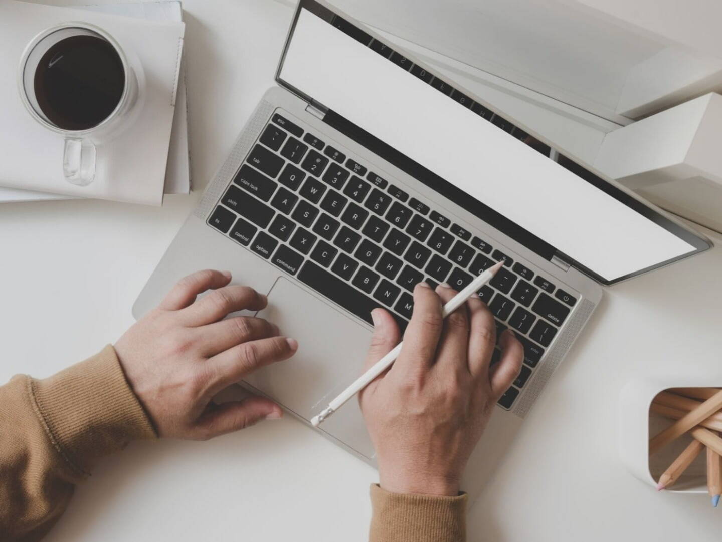 A laptop on a desk with stationary